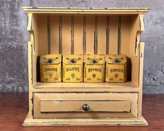 This lot features a vintage spice cabinet with four containers for various spices. It also features a place for a paper towel holder rod. This spice cabinet measures, 12.5” H x 13.5” W x 6” D.