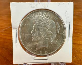 This lot features a 1925 Peace Dollar. The Peace dollar, a US silver dollar coin, was minted to commemorate the end of World War I and to symbolize the country’s hope for lasting peace. It was designed by Anthony de Francisci and was struck in 1921 and 1922 in high relief before being switched to a lower relief design in 1922. The coin was first minted in 1921 and continued to be produced until 1928, and then again in 1934 and 1935.