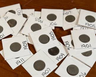 This lot features twenty-four (24) “V” nickels from various years, kept in protective slips. The “V” nickel, officially called the Liberty Head Nickel, was a U.S. five-cent coin minted from 1883 to 1912, with a few produced in 1913. It earned its nickname due to the large Roman numeral “V” on the reverse, representing the coin’s denomination. The coin was designed by Charles E. Barber, the U.S. Mint’s Chief Engraver.