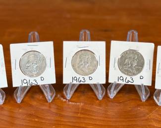 This lot features five (5) silver Franklin half dollars from 1963, kept in protective slips. 90% silver. The Franklin Half Dollar is a silver coin minted by the United States Mint from 1948 to 1963. It features Benjamin Franklin on the obverse and the Liberty Bell on the reverse. The coin was designed by John R. Sinnock, with some design elements added by Gilroy Roberts after Sinnock’s death. The Franklin Half Dollar marked the end of the “golden age of American coinage art” and the shift from allegorical figures to historical figures on coins.