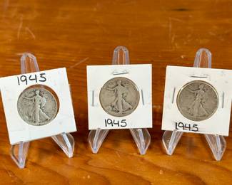 This lot features three (3) Walking Liberty Half Dollars from 1945. The Walking Liberty Half Dollar is a silver 50-cent coin issued by the US Mint from 1916 to 1947. Designed by Adolph Weinman, it features Lady Liberty walking towards the rising sun, a design considered iconic and beautiful. These coins were minted at the Philadelphia, Denver, and San Francisco mints.