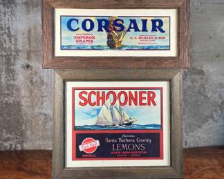 This lot features a pair of vintage framed fruit box labels, both framed with reclaimed wood. One is for Corsair Grapes and the other for Schooner Lemons.