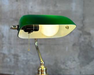 This lot features a vintage banker’s lamp in good working condition. This banker’s lamp measures, 15” H x 10.25” W x 8” D.