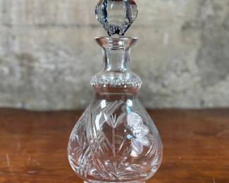 This lot features an antique etched crystal decanter. This etched crystal decanter measures, 10.5” H x 5.5” W x 5.5” D.