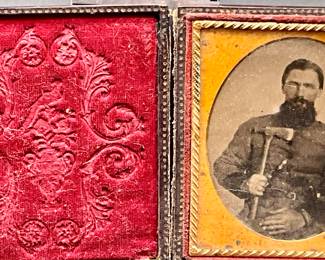 ambrotype portrait of a man with a beard, holding what appears to be a hatchet or small axe