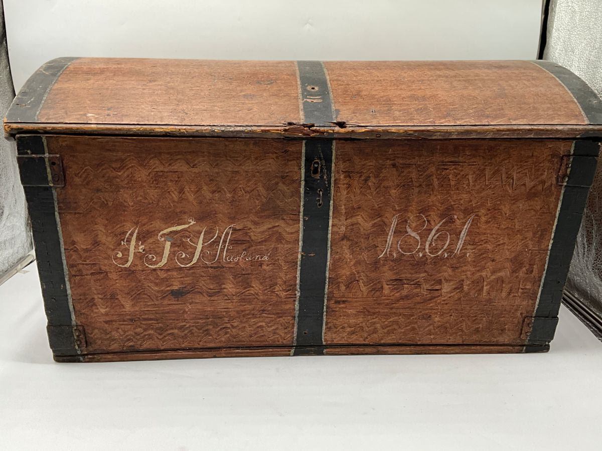 Antique Folk Art Immigrant  chest or trunk offers grain painted wood construction with central date of 1861, strap hinges and interior patch box and drawers as
photographed