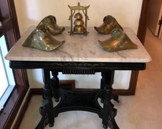 Victorian ebonized marble top table with antique brass stirrups on top 