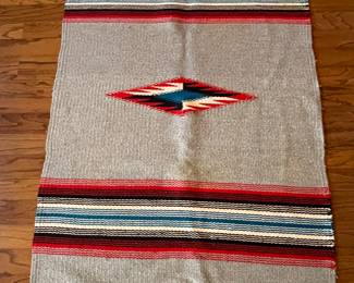 Blanket to wear as a coat, wrapped around a person, Ortega’s weaving