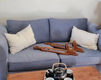 blue love seat, cedar chest, mirrored candle holders, framed artwork and throw rug