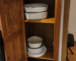 vintage cabinet filled with pyrex and corningware