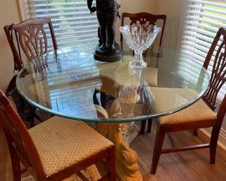 48” glass top table with dolphin base and a set of 4 mahogany dining chairs