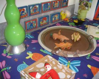 Green lamp base, animal print tablecloth, painted wooden child's blocks, Alessi figures, miniature wood cars