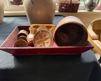 Red paint wooden tray with group of early butter stamps.