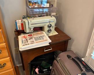 Sewing Machine in stand along with sewing supplies