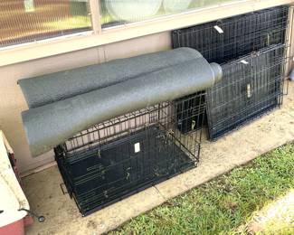 Three folding dog kennels with rubber floor mats.