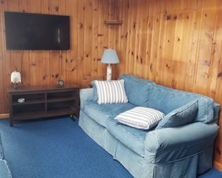 Denim slipcovered couch. Knotty pine paneling