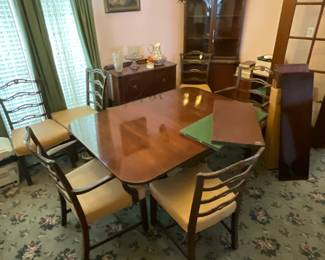 Antique Cherrywood ding table with 5 leaves and pads, extends to 10’ in great condition. Comes with 8 chairs that have been recovered with E-Z clean stain resistant material.              A high quality Dining Table.                            In the background is an antique wood corner hutch that would go well with the table set.  Also a small side table/cabinet. Hutch and side board to be sold separately 