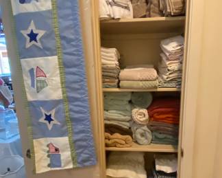 Quilt and closet of bath washcloths, hand and bath towels, sheets and pillowcases etc.