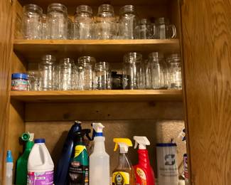 Laundry room cabinet on left - glass jars of all sizes & miscellaneous cleaners