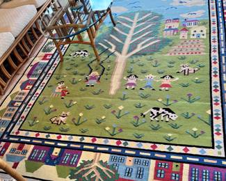 LARGE AREA RUG DIPTICING COUNTRY SIDE TOWN WITH HOMES, CHILDREN AND ANIMALS WITH LARGE TREE IN CENTER.