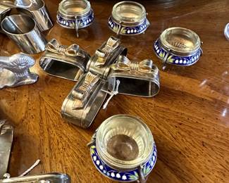 Another view of the silver and gold metal ribbon/bows napkin rings, and a set of four beautiful vintage 1960s/1970s Russian white metal and enamel salt cellars with removable glass bowl inserts. Enamel has white snowdrop blossoms on a dark blue background.