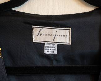 Closeup of a Spenser Jeremy 100% silk black with gold rope crest/shield vest