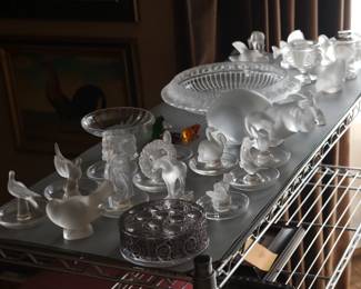 Just some of the stunning collection of Lalique crystal glass pieces including a Lalique Marguerites bowl, a set of Lalique frosted crystal sparrows, a signed Lalique "Gregoire" frog / toad figurine, several animal form pin trays/ring holders, a vintage Lalique frosted crystal “crouching cat” sculpture, and several more Lalique items!