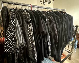 Another rack of vintage men's clothing including black shirts, sport coats, and wool overcoats