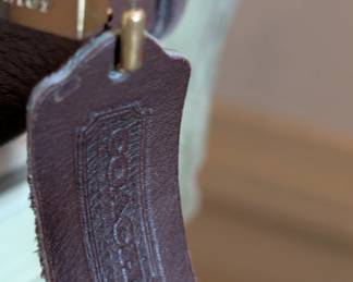 Closeup of vintage Coach leather satchel bag with brass hardware, beautiful mocha color leather