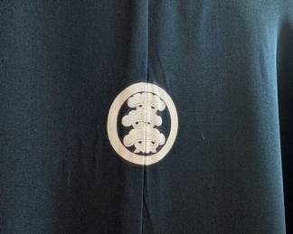 Closeup of a vintage Japanese men's black silk Montsuki Five Family Crest formal kimono