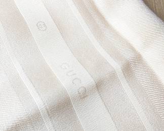 Closeup of Gucci monogram white silk scarf