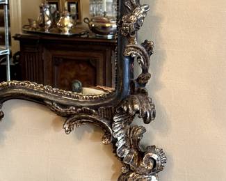 A closeup of lower right corner of the gorgeous pierce carved polychrome giltwood rococo style mirror, ornately pierce carved with foliate and leaf scrollwork