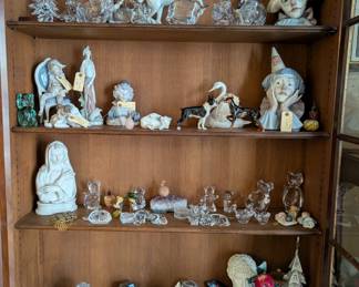 Collectibles including Lladro porcelain figurines Clown "Sad Jester" #5129, Pensive Clown #5130, Dog And Butterfly #4917; Harlequin with Cat #1229, Don Quixote Standing #4854; Royal Copenhagen Playing Polar Bear Figurine #729, vintage Hutschenreuther Doberman figurine and Hutschenreuther Boston Terrier figurine; a Boehm “La Pieta Madonna" bisque porcelain bust with matching plinth, several crystal glass animal figurines, Christmas tree sculptures, and more