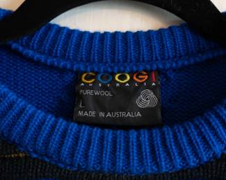 Closeup of a vintage Coogi Australia 100% wool knit pullover sweater, blue with colorful horizontal stripes, size L