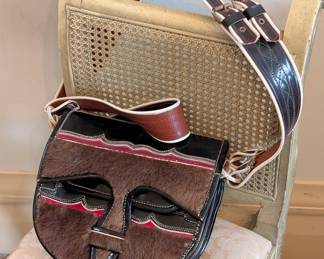 Stylish designer cross-body handbag featuring full grain and patent leather and genuine fur. Accordion expansion offers ample storage and organization.