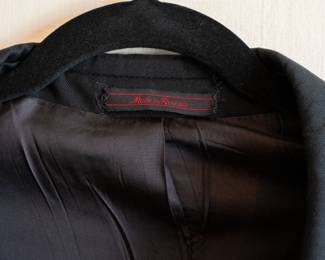 Closeup of vintage men's Etienne Aigner black suit coat or sport jacket, lined, three-button closure, made in Russia
