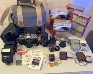 Canon AG-1 camera with accessories and case, vintage lenses, light meters, and slide cartridges