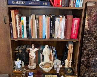 Bookshelf with assorted books and religious items
