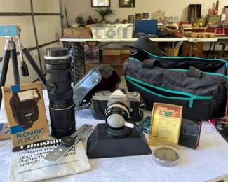 Nikomat 35 mm camera with multiple accessories, Vivitar lenses, tripod, Promatic FT 1700, and Coast camera case. (By Nikon)