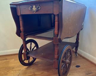 Antique wheeled tea cart table with drop leaves. Slide out glass shelf and drawer