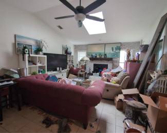 Living room, tiffany style lamp, large Buddha, shelving, TV , leather recliner, boxes etc