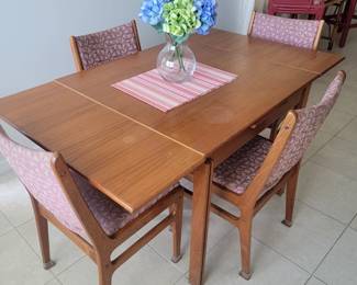 Teak colored table with fold out leafs and 4 chairs