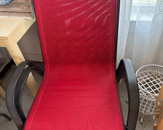 Red mesh patio chair with dark frame.