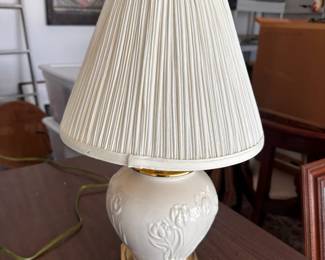 White ceramic table lamp with pleated shade.