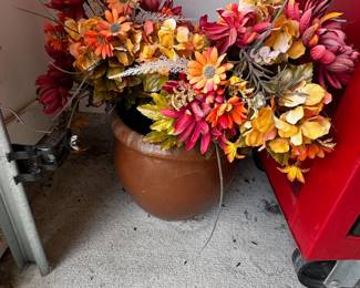Artificial fall flower arrangement in terracotta pot.