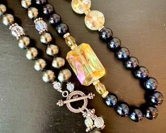 ($48; beaded necklace with front clasp) ($42; black round bead and clear faceted bead necklace)
