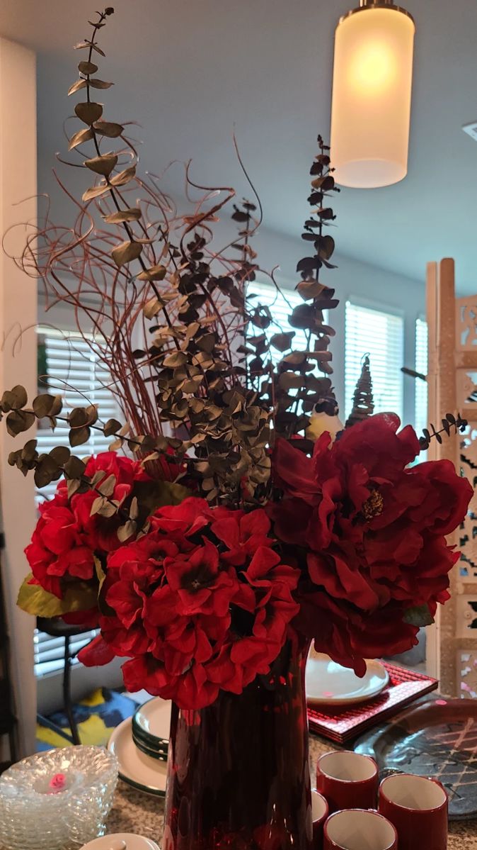 Beautiful flower arrangement in red vase.