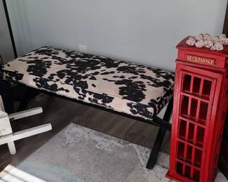 Cowhide bench and a small London phone booth style shelf stand with door.