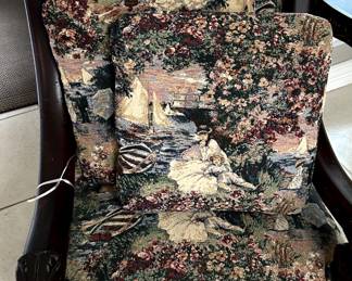 Chair with carved detail and extra cushions.