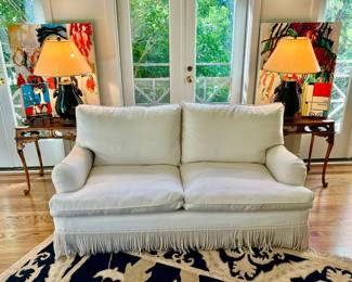 Like new white loveseat with fringe, feather down.